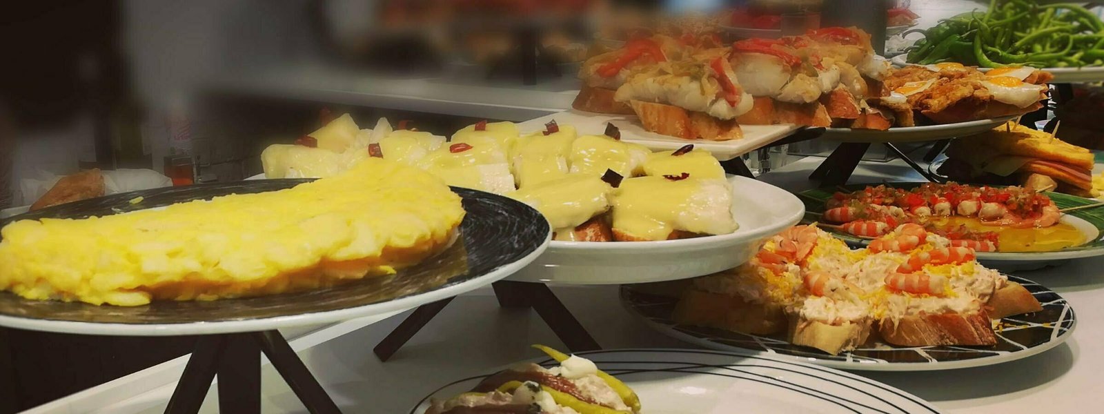 various plates of pintxos arranged on a bar in San Sebastian, the Basque Country region of Spain