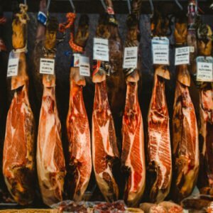 A line of Iberico hams hang from a ceiling in a restaurant