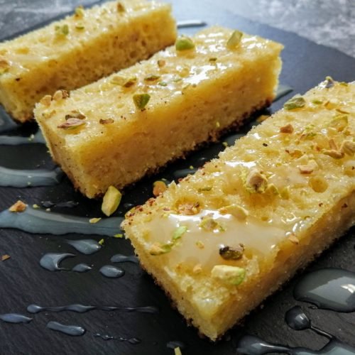 a slate plate holds slices of Lemon & olive oil bizcocho