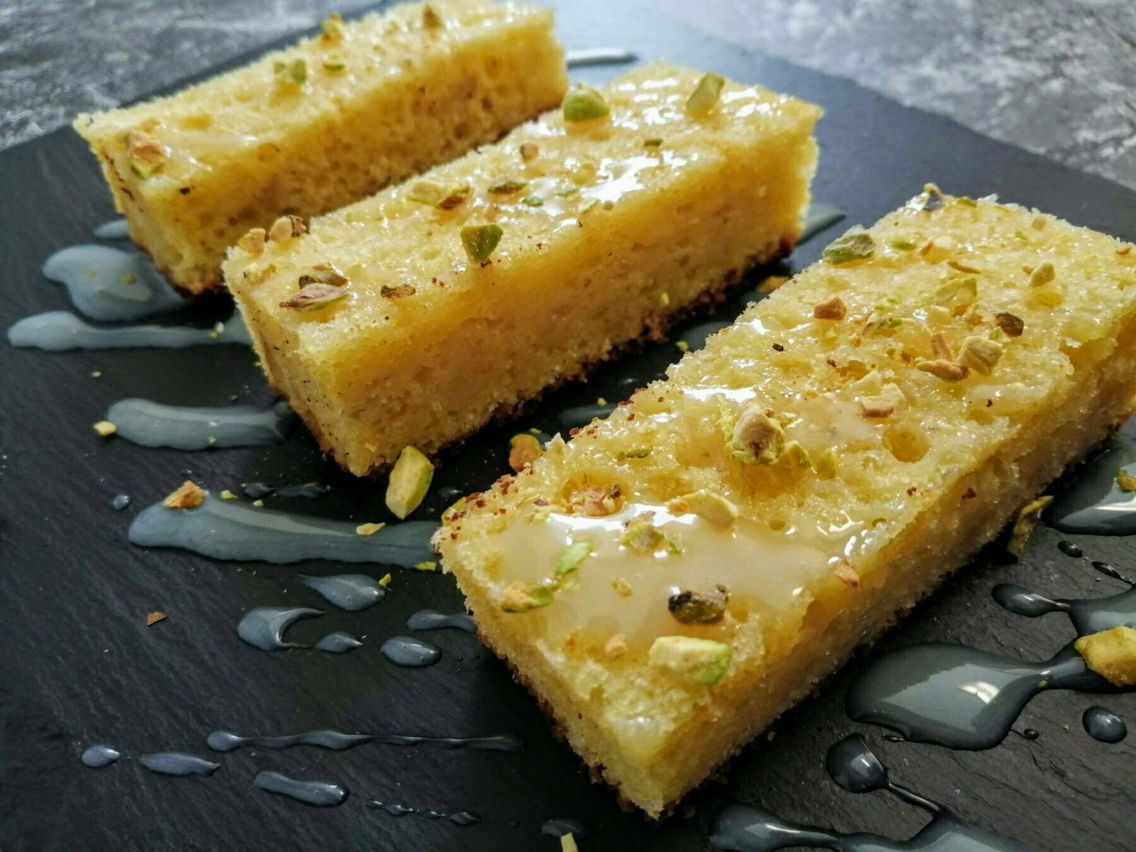 a slate plate holds slices of Lemon & olive oil bizcocho