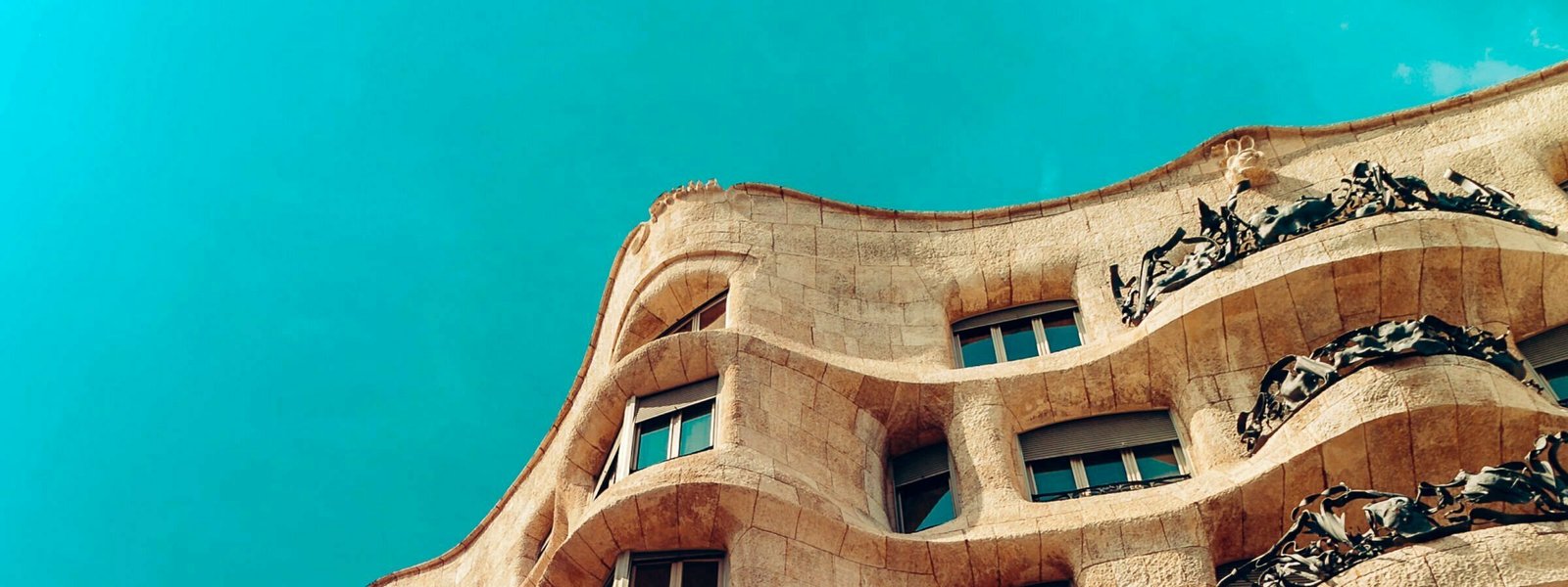 Curves of a building tower above with a blue sky in the background