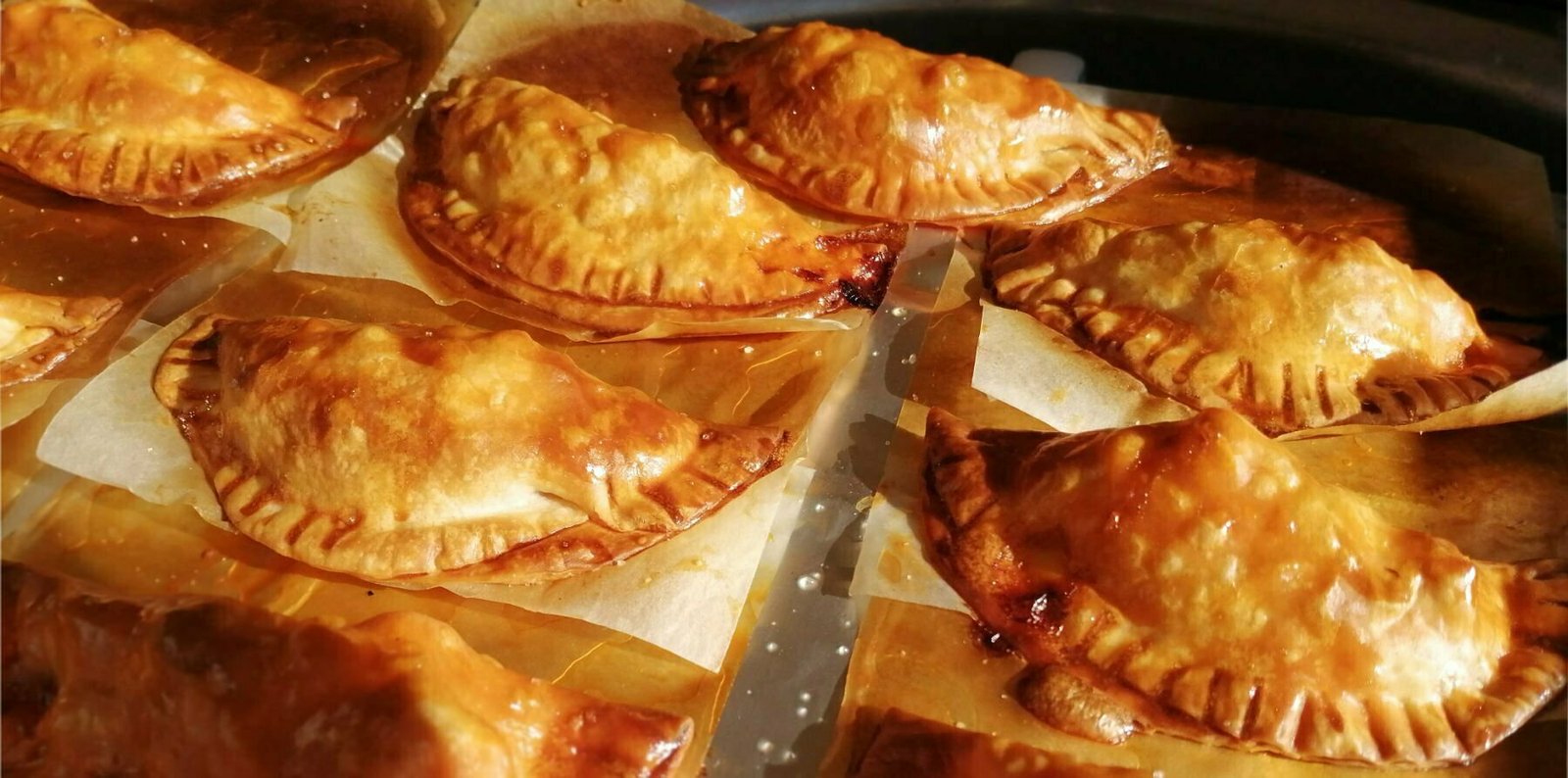 a tray of baked chicken with cider infused chorizo empanadas