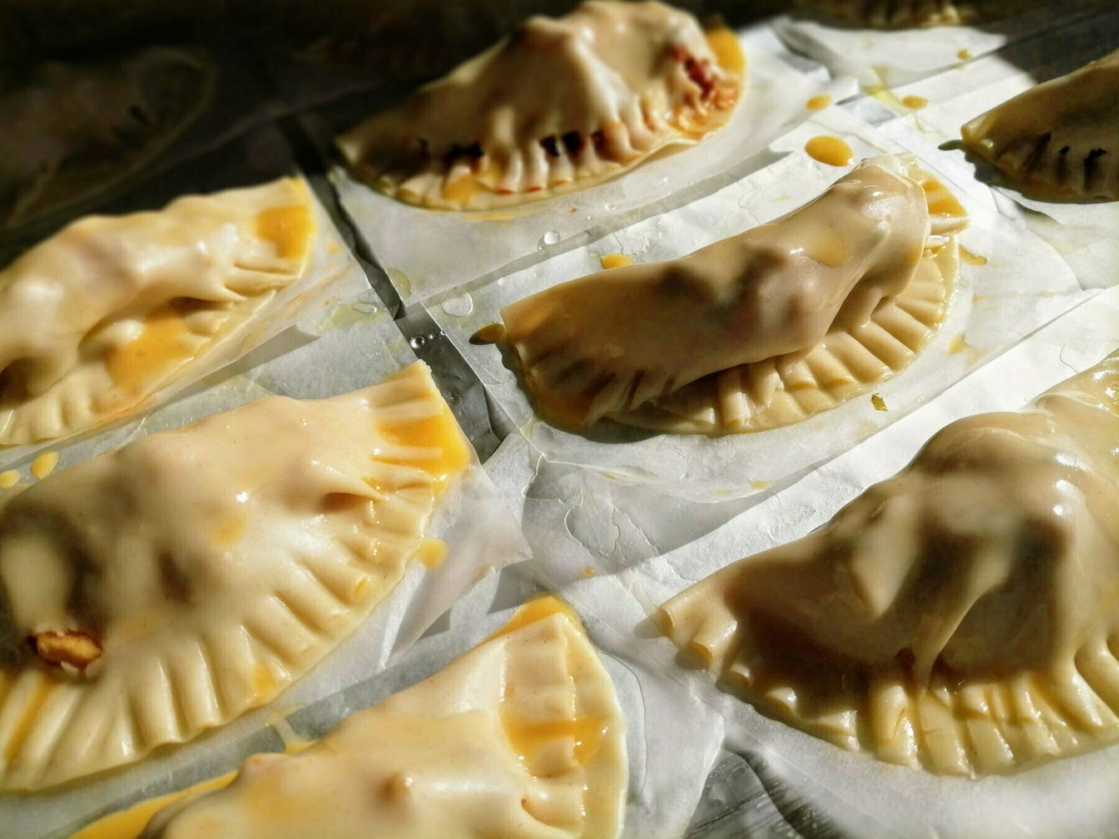 unbaked chicken with cider infused chorizo empanadas sit on a baking tray