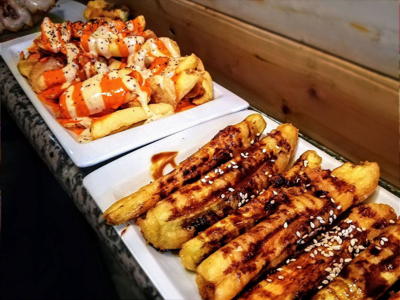 two plates of tapas sit on a counter in a bar in madrid