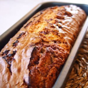 A freshly baked mulberry bizcocho sits in a cake pan waiting to be served