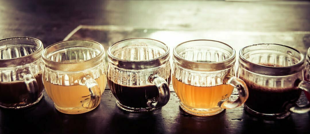 a row of Murcian coffee sits on a rustic wooden counter