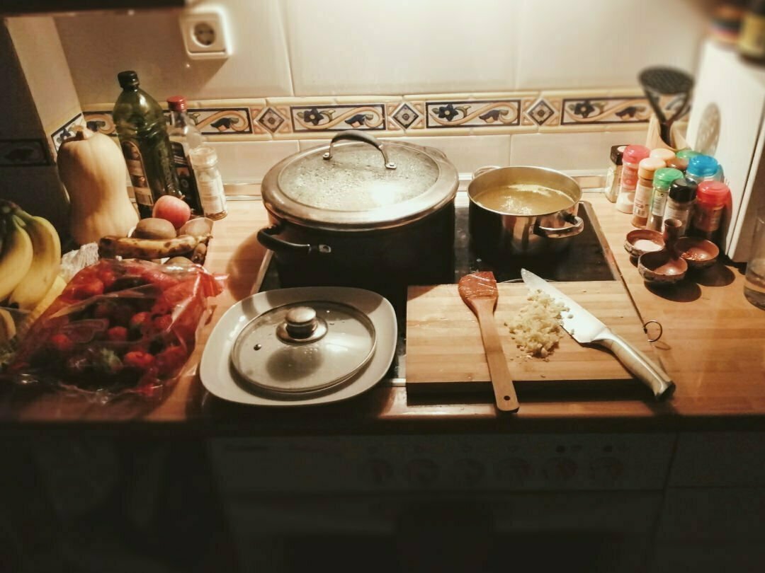 A shot of a kitchen with a cooker, hob, chopping board, and some spices