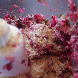 Blended ingredinets for the falafel mixture sits in a food processor with some breadcrumbs sprinkled on top