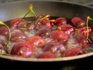 a pan of cherries simmers on. stovetop