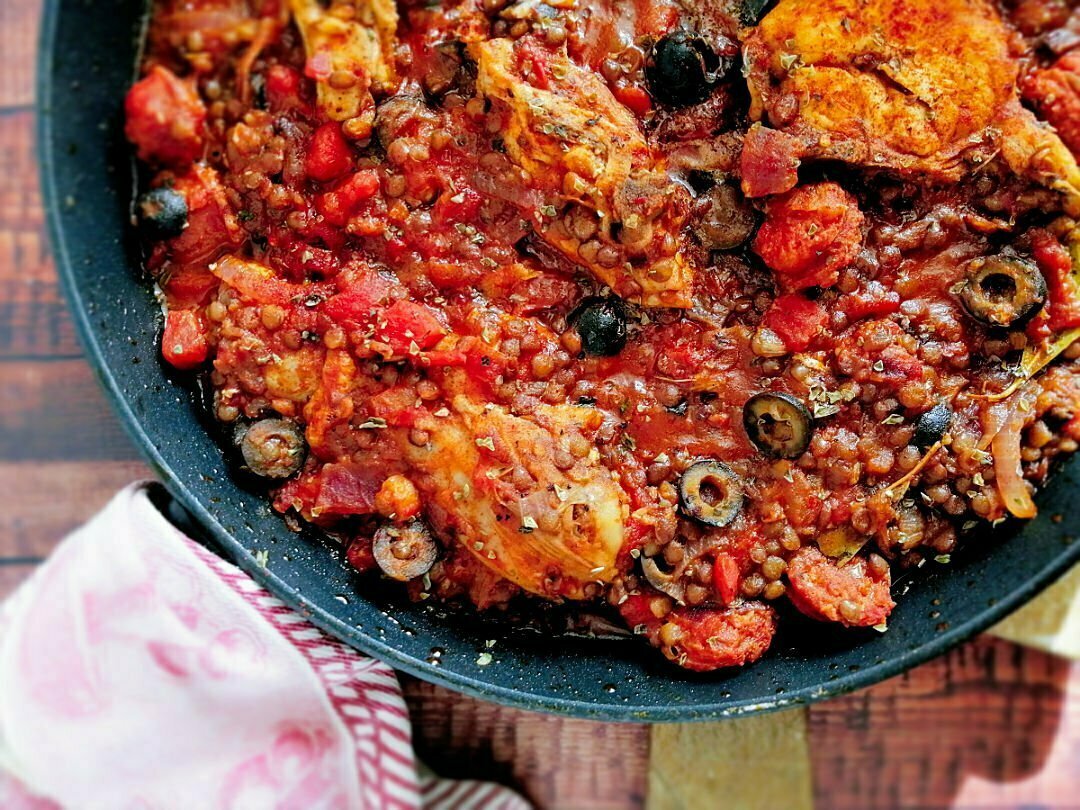 A close up shot of a pan full of chicken and chorizo stew