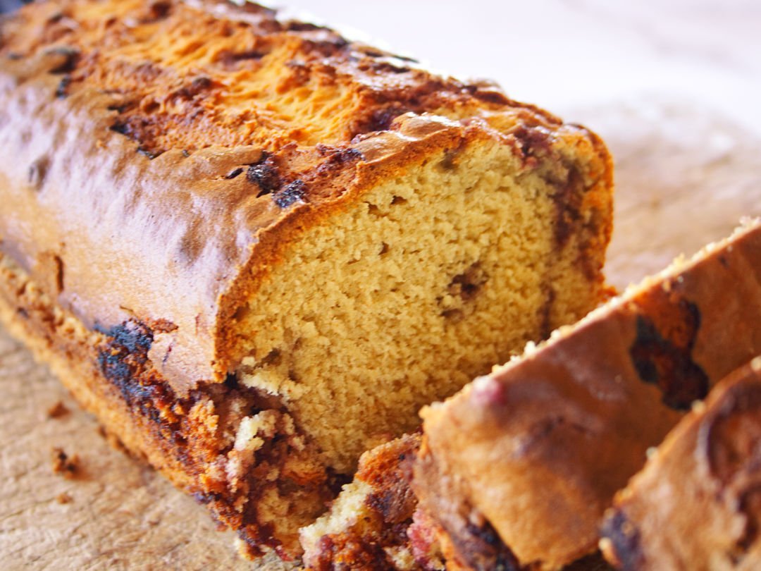 A freshly baked mulberry bizcocho sits sliced on a chopping board