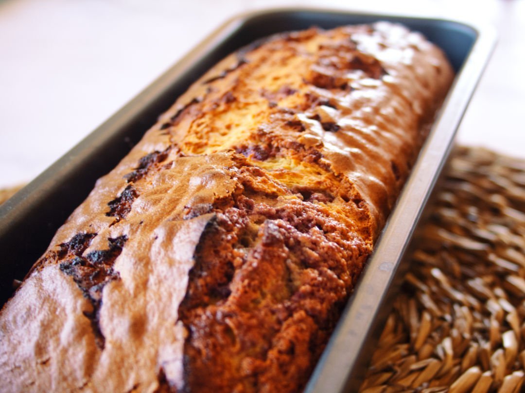 A freshly baked mulberry bizcocho sits in a cake pan waiting to be served