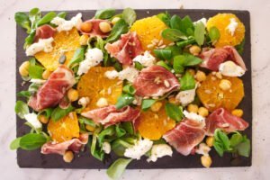 a jamon iberico salad sits on a slate plate