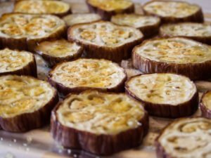 roasted eggplant slies sit on a baking tray