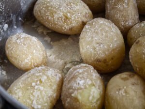 some papas arrugadas sit in a pot with lots of salt