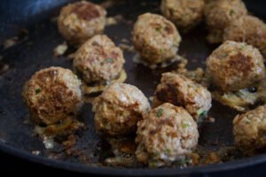 small albondigas fry in a saucepan