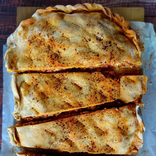 a large empanada gallega is cut into some large slices