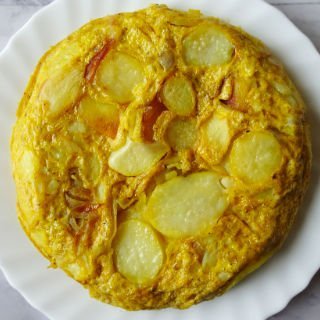 a tortilla espanol sits on a white plate