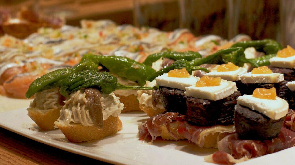 various tapas dishes are laid out on a large counter top