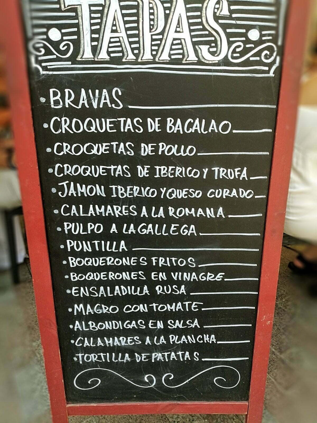 a tapas board outside of a busy tapas restaurant in Valencia