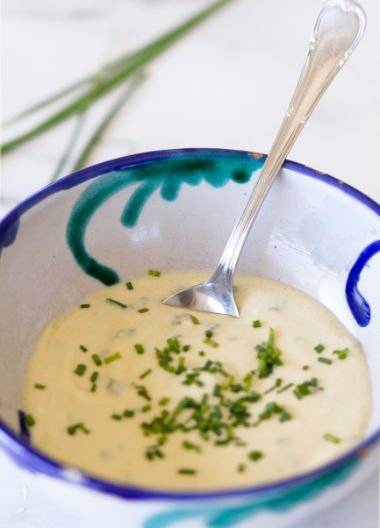 a small bowl of healthy yogurt salad dressing with chives garnishing