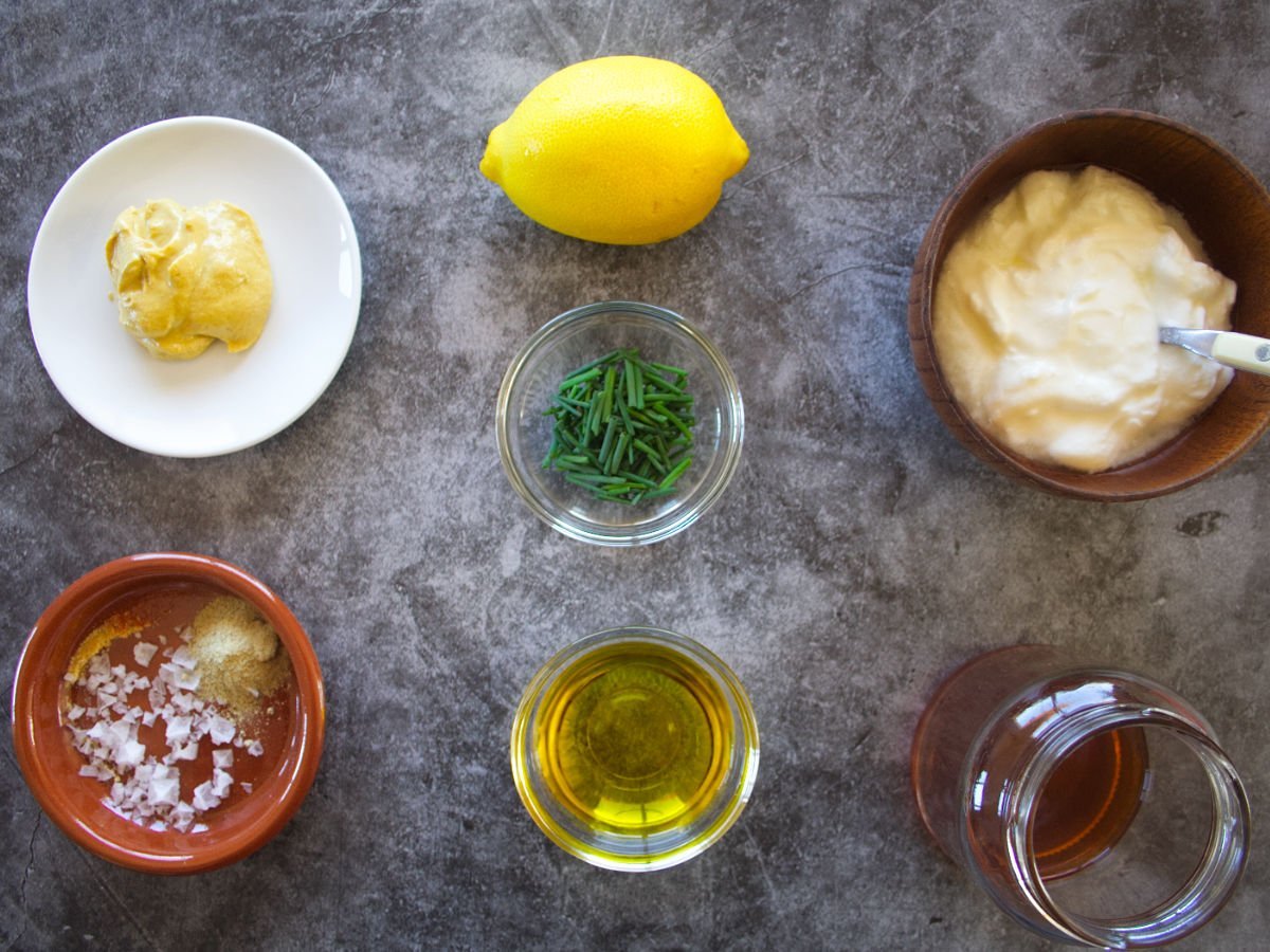 ingredients used for making the yogurt salad dressing are laid out on a counter