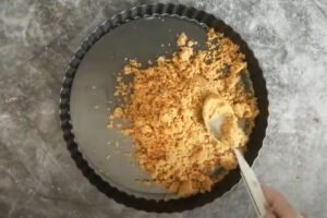 The biscuit base is added to a baking tray