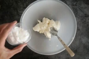 cream cheese and icing sugar are added to a mixing bowl