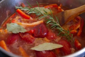 tomato, bay leaves, and a stick of romesmary simmer on top of a rich red sauce