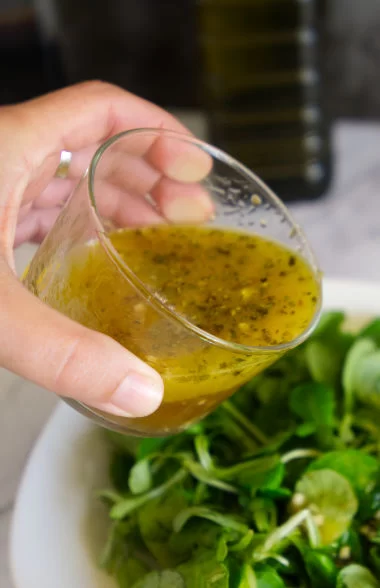 mediterranean salad dressing is drizzled onto a salad