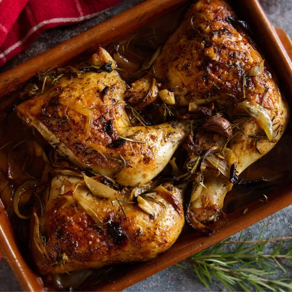 A large try of oven-baked chicken pieces (pollo al horno) sits waiting to be served.