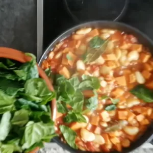 Chopped spinach is added to the pan.