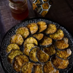 a plate of oven baked eggplant are drizzled with honey