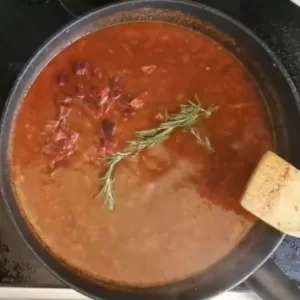 Rosemary and chili are added to a panof sauteed tomatoes.