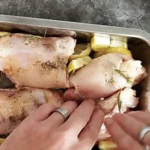 ingredients in a baking pan are mixed by hand.