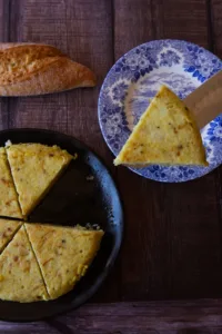 a wedge of tortilla is served onto a blue plate