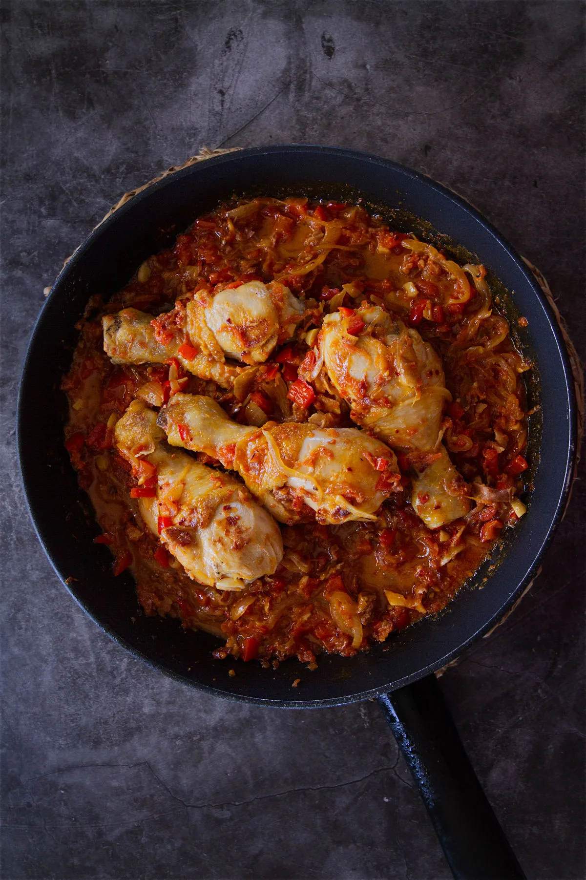 A pan of Spanish chicken chilindron with lots of sauce.