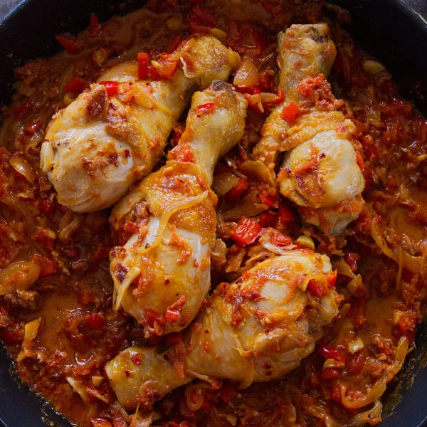 A pan of Spanish chicken chilindron with lots of sauce.