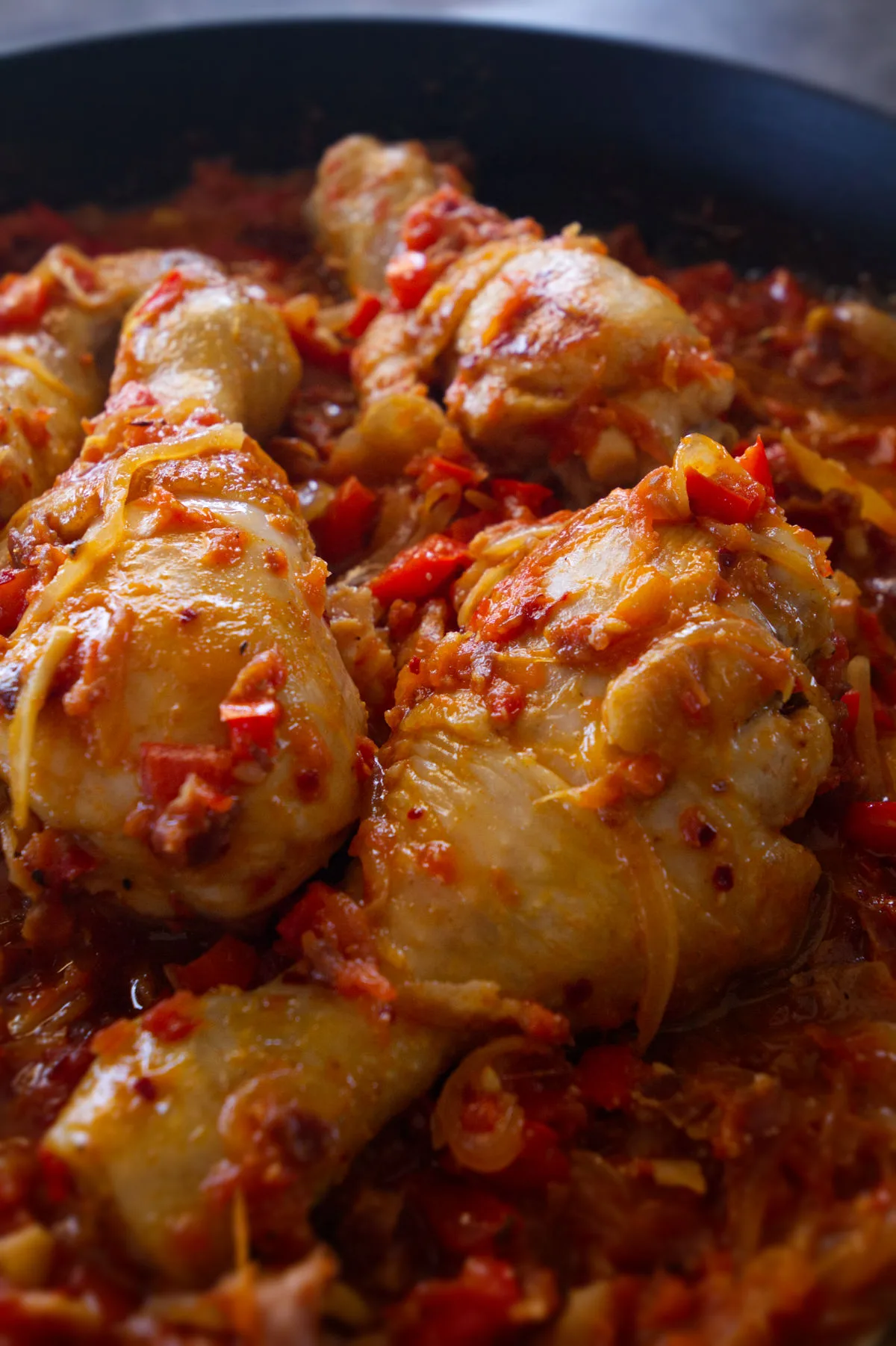 A pan of Spanish chicken chilindron with lots of sauce.