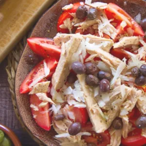 A tuna tomato salad seasoned with fresh cracked black pepper and salt.