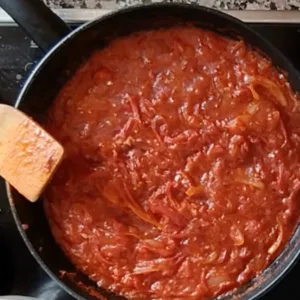 Sofrito sauce simmers in a large pan.