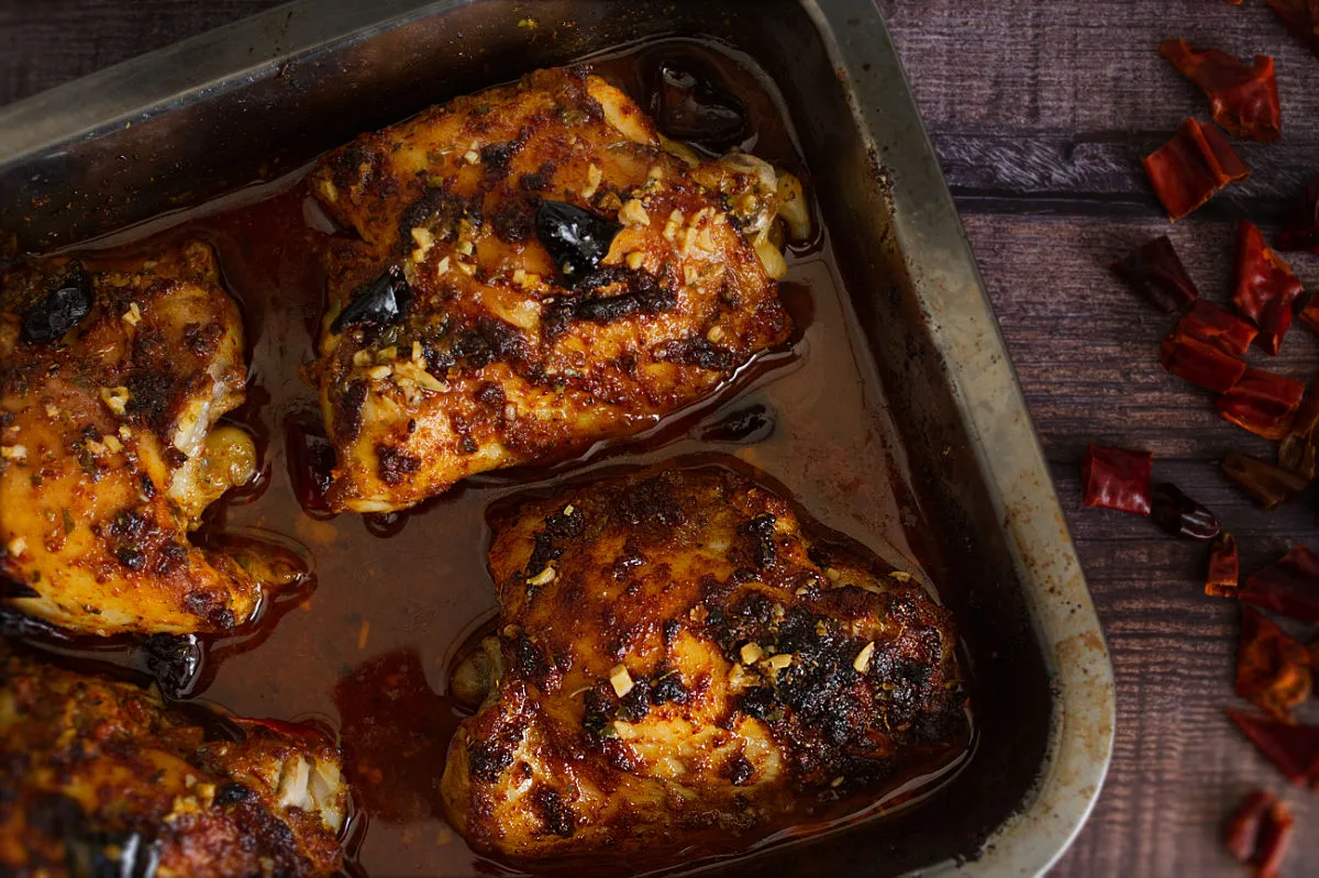 A tray of oven-baked spicy Mediterranean chicken thighs.