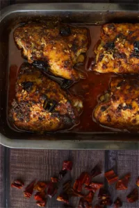 A tray of oven-baked spicy Mediterranean chicken thighs.