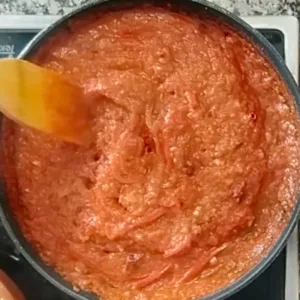 Chili sauce simmers in a large pan.