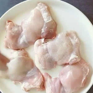 Boneless chicken thighs are seasoned with garlic and some salt.