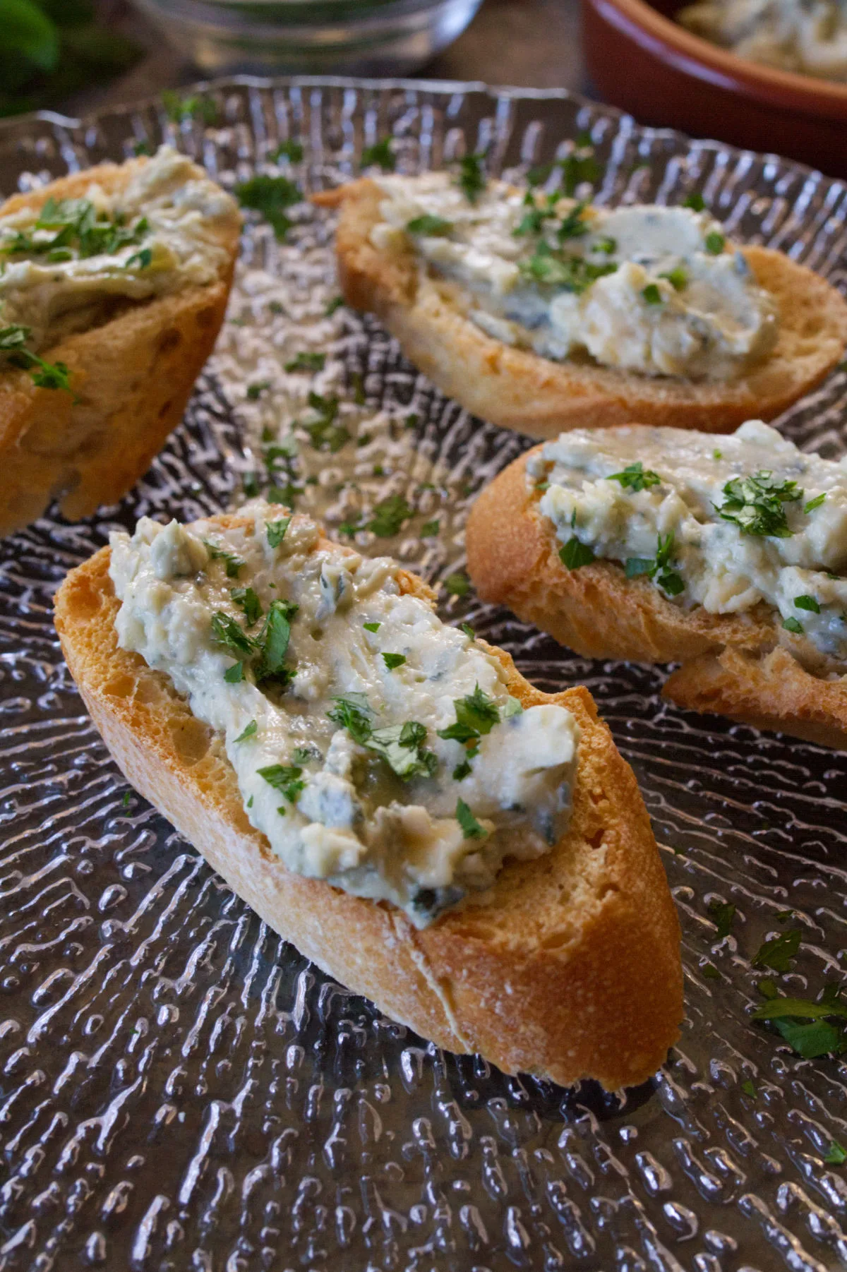 Some tapas servings of blue cheese and cherry spread served on top of toasted bread.