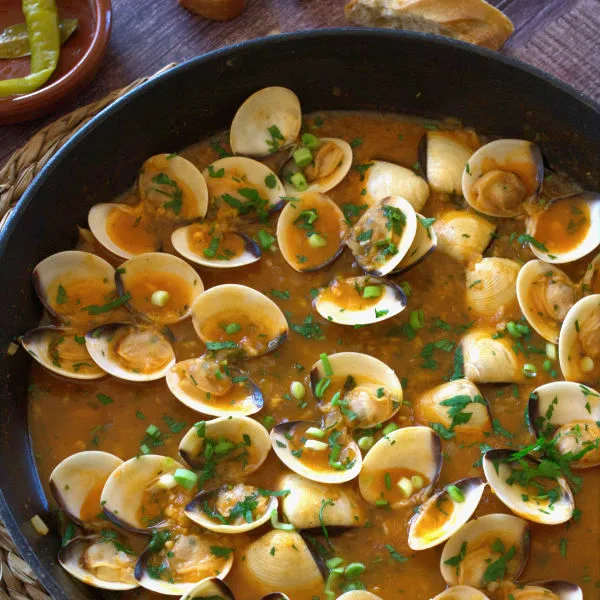 A large pan of Spanish-style clams in tomato and wine.