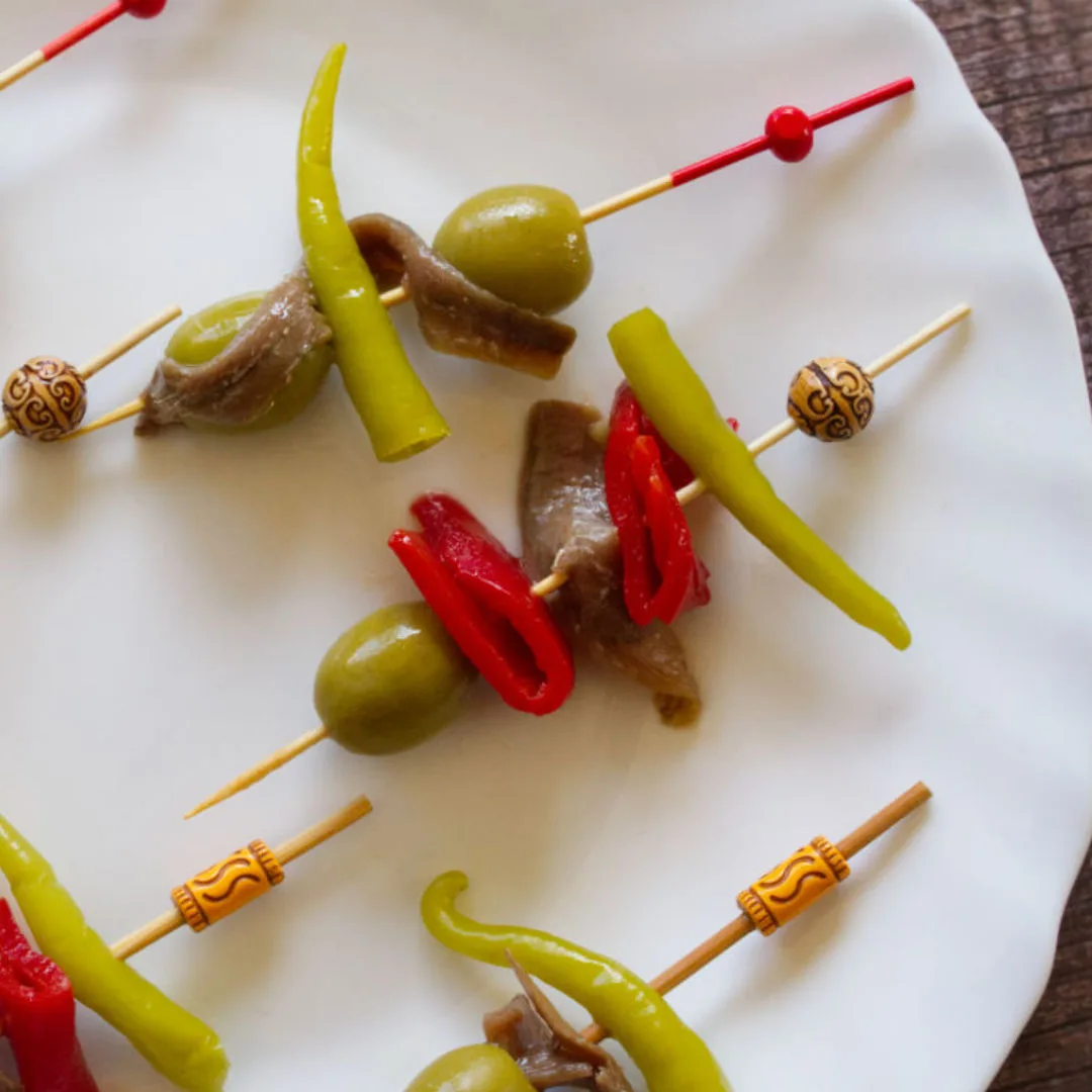 A single gilda banderilla on a white plate.