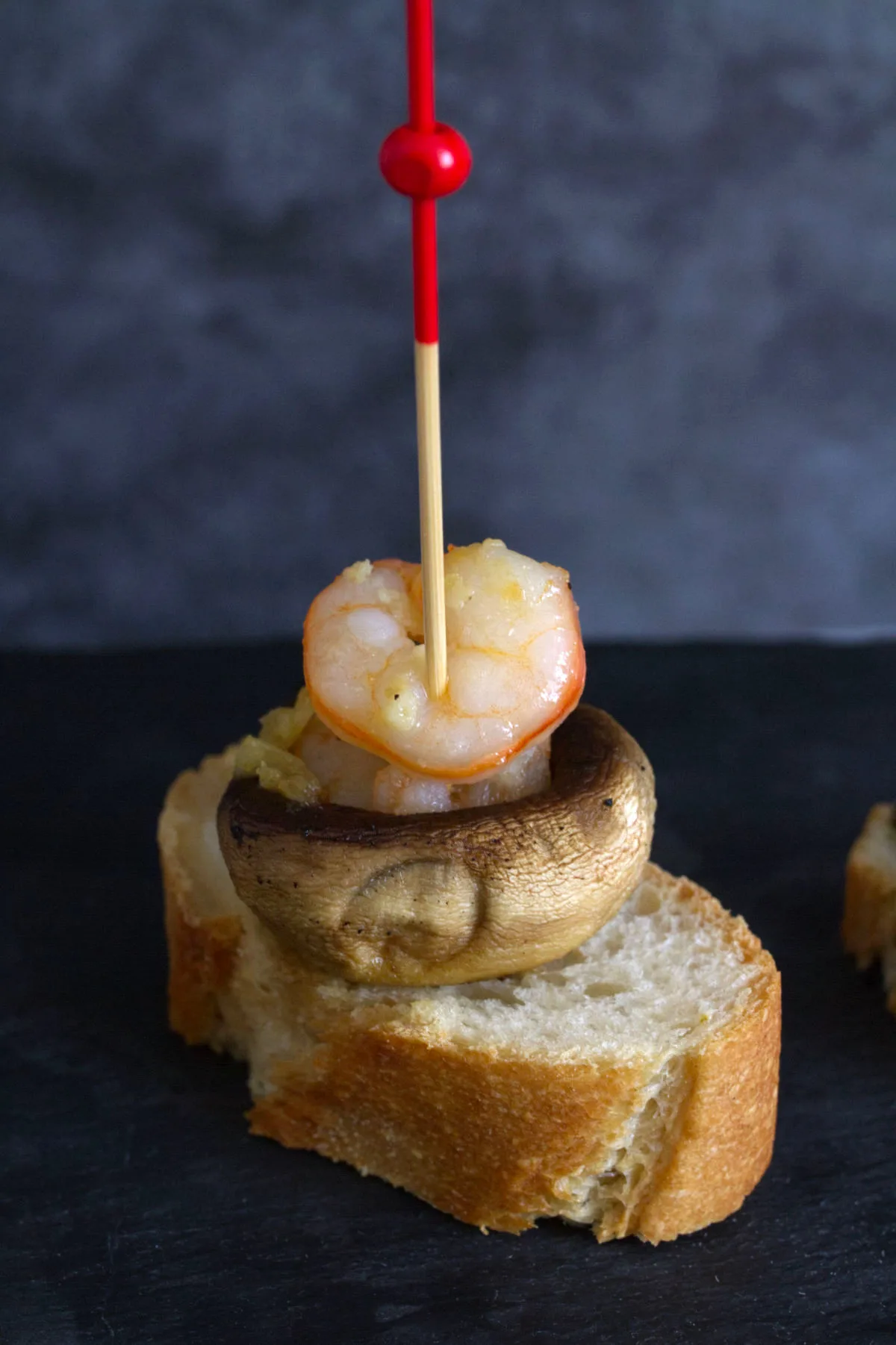 A shrimp and mushroom pintxos sits on a plate.