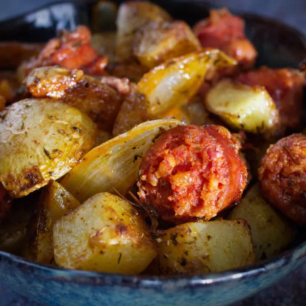 A bowl of roasted potatoes with chorizo and thyme